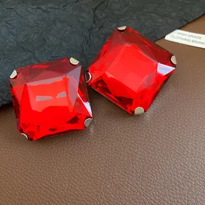 Detailed macro view of vibrant red square faceted crystal stud earrings with silver prongs.