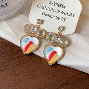 Détail des boucles d'oreilles cœur plaquées or 18k avec motif coloré et cristaux
