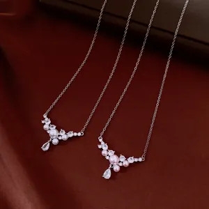 Detailed view of elegant zircon and pearl necklaces with teardrop pendants on silk