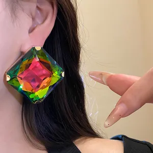 Close-up of oversized square rainbow crystal stud earring with vibrant multifaceted design