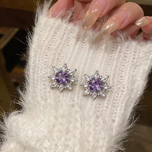 Elegant Korean style purple zircon flower ear clips displayed on a white fuzzy sweater