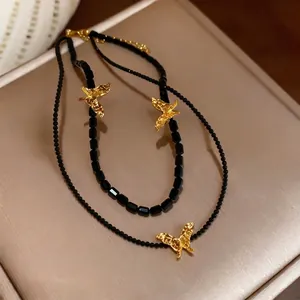 Elegant multi-layer black beaded necklace with textured golden butterfly pendants.