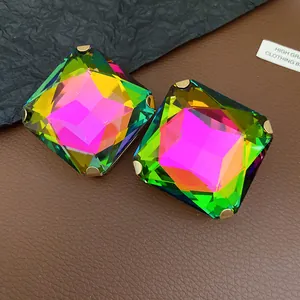 Close-up of square iridescent crystal earrings with a four-prong gold-tone setting.