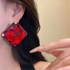 Macro detail of high-end red square crystal stud earrings with silver needles for women