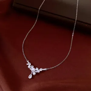 Detail shot of elegant silver necklace featuring pearls and a teardrop zircon pendant