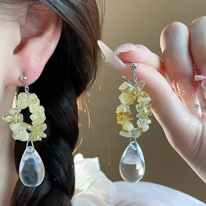 Gros plan de boucles d'oreilles en résine jaune et pendentif goutte d'eau en argent