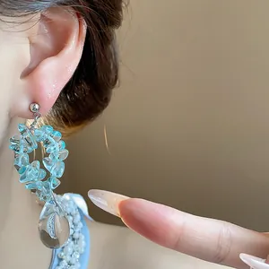 Vue détaillée macro de perles en résine bleu clair et d'un pendentif goutte d'eau