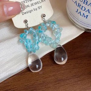 Gros plan de boucles d'oreilles en résine bleue et goutte d'eau avec clou en argent S925