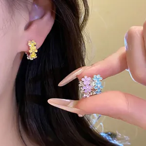 Enamel flower huggie hoop earrings featuring colorful petals and crystal accents