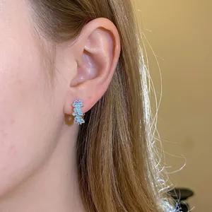 Elegant blue flower drip-oil hoop earrings for women, shown worn on a model's ear