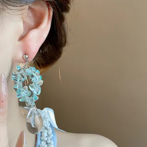 Gros plan détaillé de boucles d'oreilles en résine bleue avec goutte d'eau claire