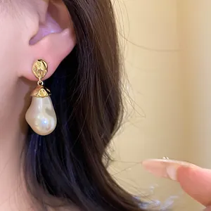 Detailed view of vintage baroque pearl drop earrings with elegant gold pleated studs