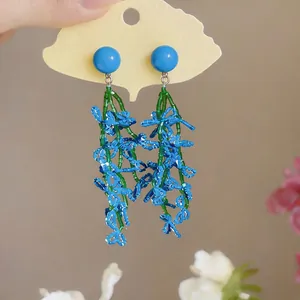 Close-up detail of summer blue beaded tassel earrings with a floral-inspired design.