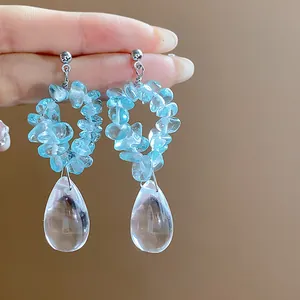 Vue détaillée de boucles d'oreilles en résine bleue et pendentifs goutte d'eau