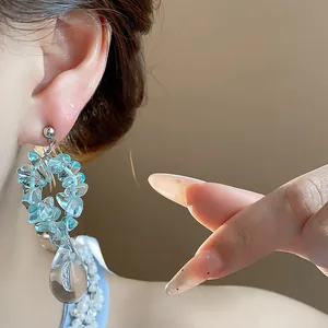 Vue détaillée de boucles d'oreilles en résine bleu clair avec pendentif goutte d'eau