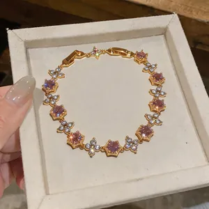 Detailed view of 18k gold plated bracelet with purple cubic zirconia flower charms