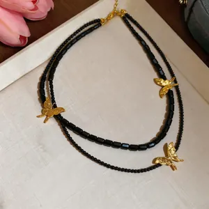 Detail of French vintage multi-layer necklace with black beads and gold butterfly pendants