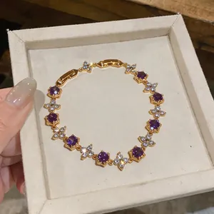 Exquisite close-up of 18k gold plated bracelet featuring purple and white zircon stones