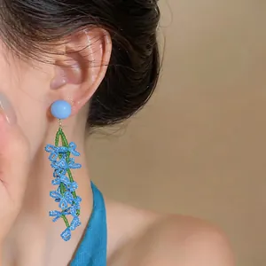 Close-up of elegant blue beaded tassel earrings on model for summer vacation style