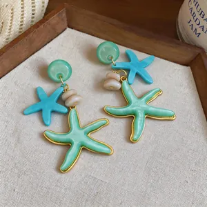 Primer plano detallado de los pendientes de estrella de mar en resina verde y azul