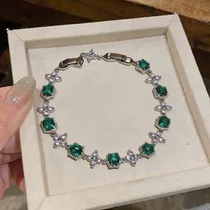 Close-up of elegant green zircon flower bracelet inside a light beige jewelry gift box