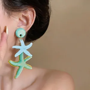 Detalle de primer plano de pendientes de estrella de mar de resina en modelo asiática