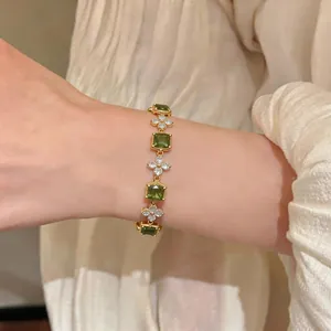 Elegant 18k gold plated bracelet featuring square green zircons and sparkling flower charms