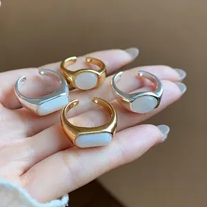 Anillos abiertos minimalistas bañados en oro 18k con resina blanca sobre la mano