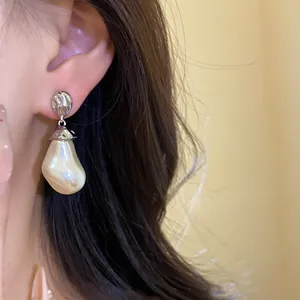 Detail view of a baroque pearl earring with textured silver stud on ear