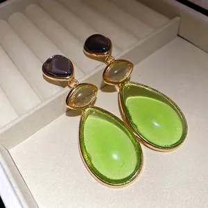 Vintage-style gold-tone dangle earrings with green and purple resin teardrop pendants.