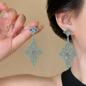 Exquisite turquoise and pink crystal geometric flower drop earrings shown on model ear