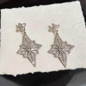 Detailed close-up of exquisite star-shaped diamond-encrusted drop earrings for women