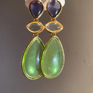 Close-up detail of vintage resin waterdrop earrings featuring purple and green stones.