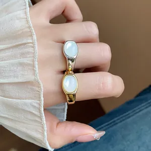 Detalle de anillos abiertos geométricos bañados en oro de 18k con resina blanca