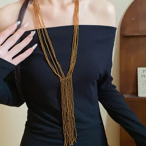 Detail of ethnic multi-layer beaded tassel necklace cascading over black off-shoulder top