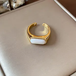 Vista detallada de un elegante anillo abierto chapado en oro de 18 quilates con resina blanca.