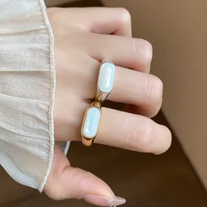 Primer plano de elegantes anillos geométricos chapados en oro y plata con resina blanca.