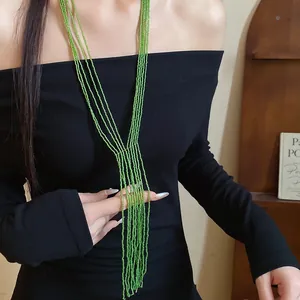 Close-up detail of vintage ethnic green multi-layer seed bead tassel necklace on model