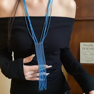 Detail view of multi-strand blue crystal beaded tassel necklace on a model