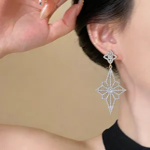 Close-up of elegant silver needle diamond rhombus flower dangling earring on model
