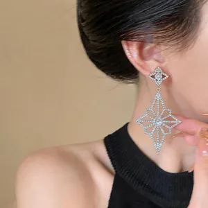 Detailed view of elegant geometric flower drop earrings with sparkling rhinestones