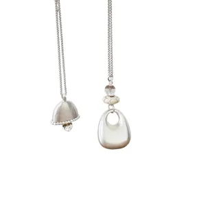Elegant silver oval pendant necklace with bell and heart details for a chic style.