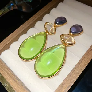 Detailed macro view of vintage resin teardrop earrings in a wooden jewelry box