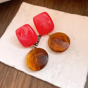 Vue détaillée de boucles d'oreilles vintage en résine aux textures marbrées rouge et marron