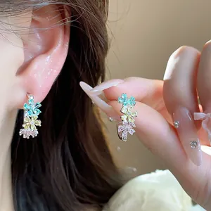 Detail shot of elegant three-color zircon flower C-shaped earrings worn by an Asian model