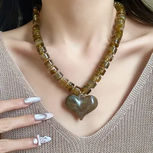 Dettaglio di una collana con ciondolo a cuore in acrilico marmorizzato sul modello