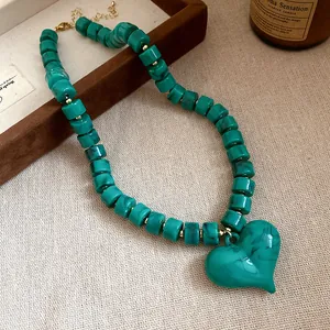 Vista dettagliata di una collana di perle acriliche verdi marmorizzate con ciondolo a cuore