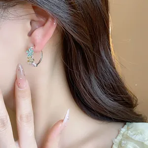 Detailed close-up of elegant C-shaped hoop earrings with colorful zircon flowers