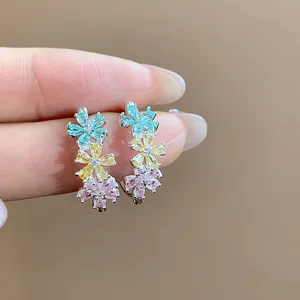 Detailed view of C-shaped earrings featuring mint, yellow, and pink zircon flowers
