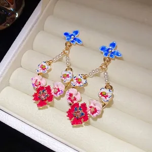 Elegant vintage floral drop earrings with white pearls and rhinestones on silver needles
